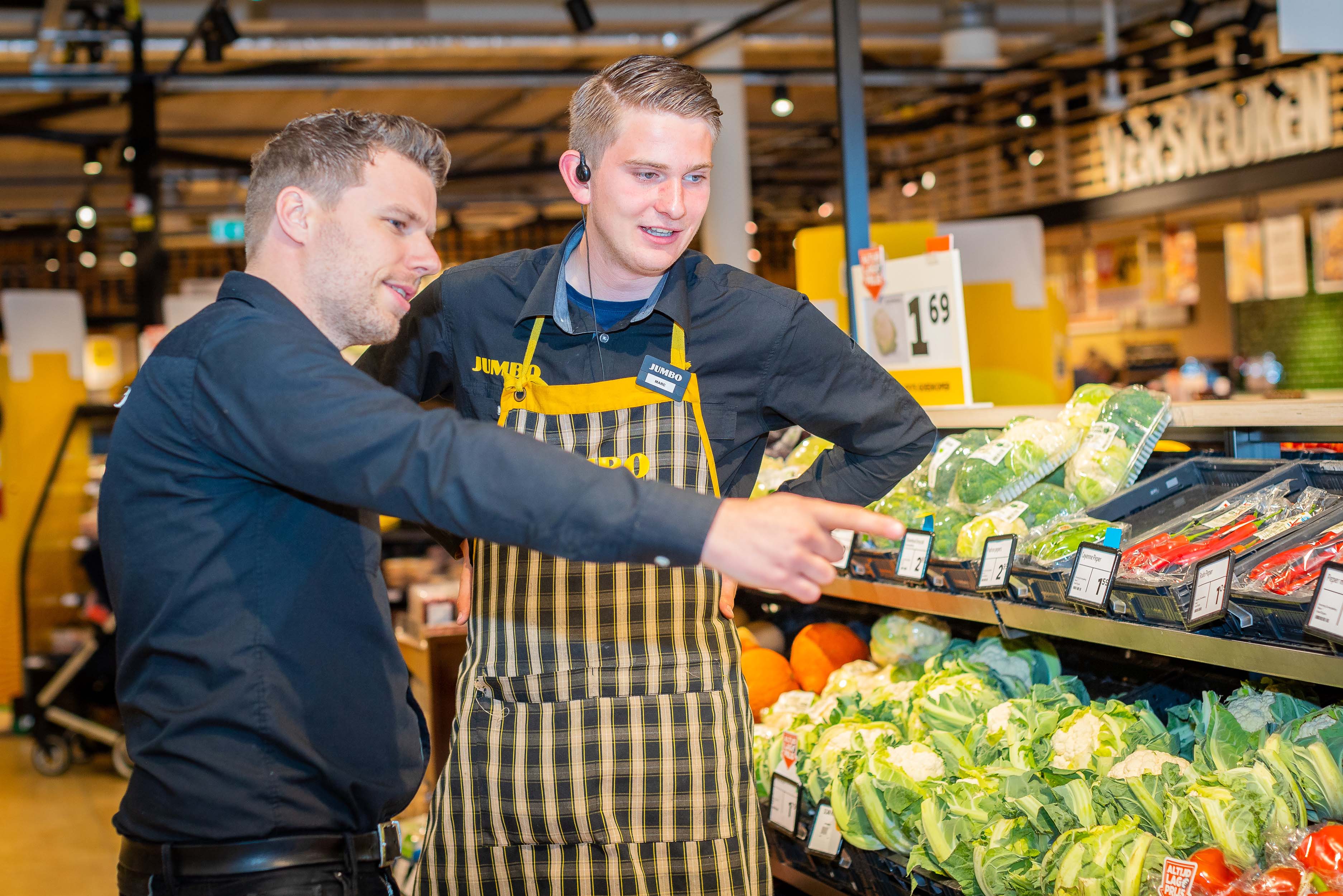 Leidinggevende bespreekt met medewerker de kassa en winkelindeling bij Jumbo Maripaan.