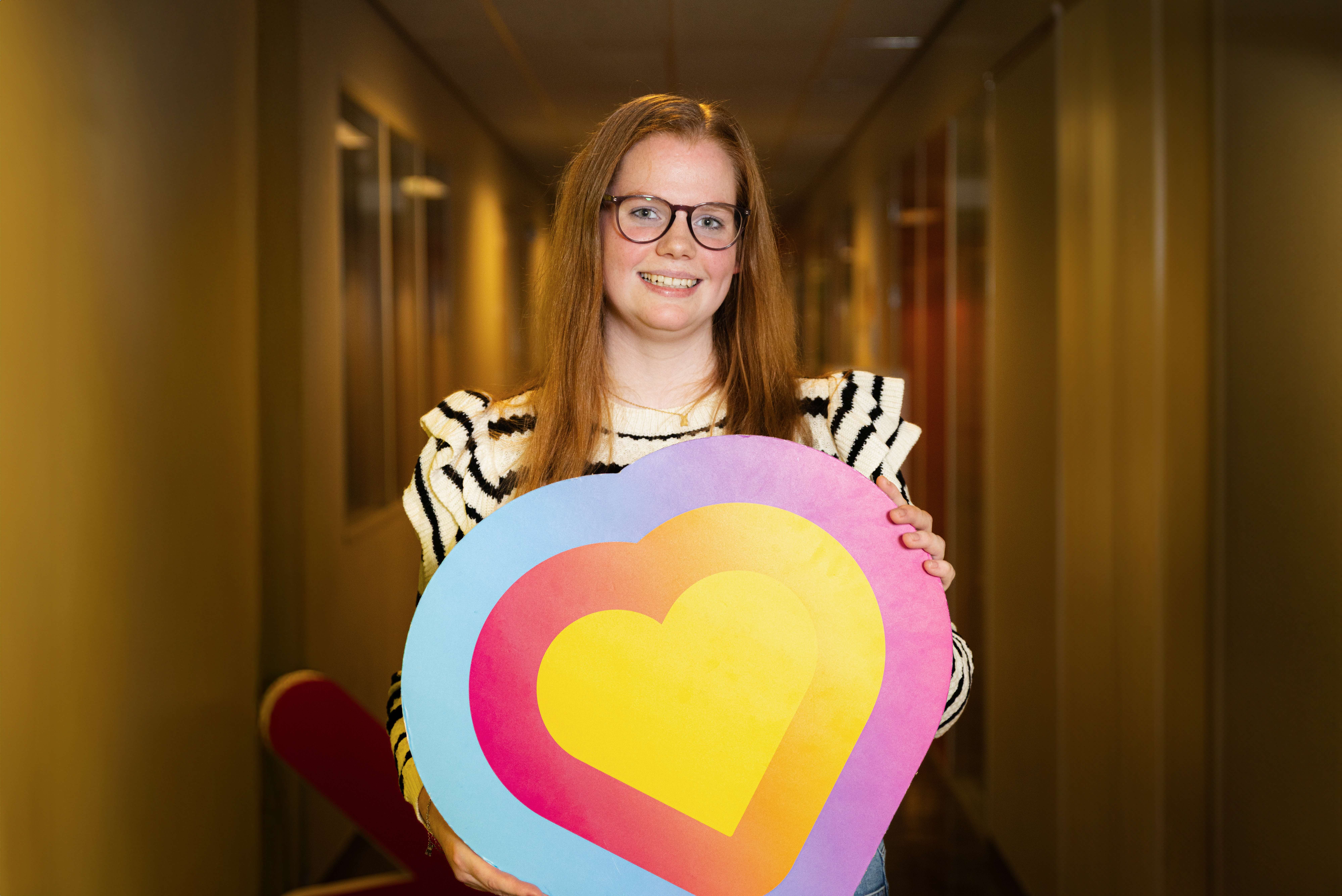 Jessica Huttinga houdt een kleurrijk hart vast als symbool voor lef en passie bij Noorderpoort.