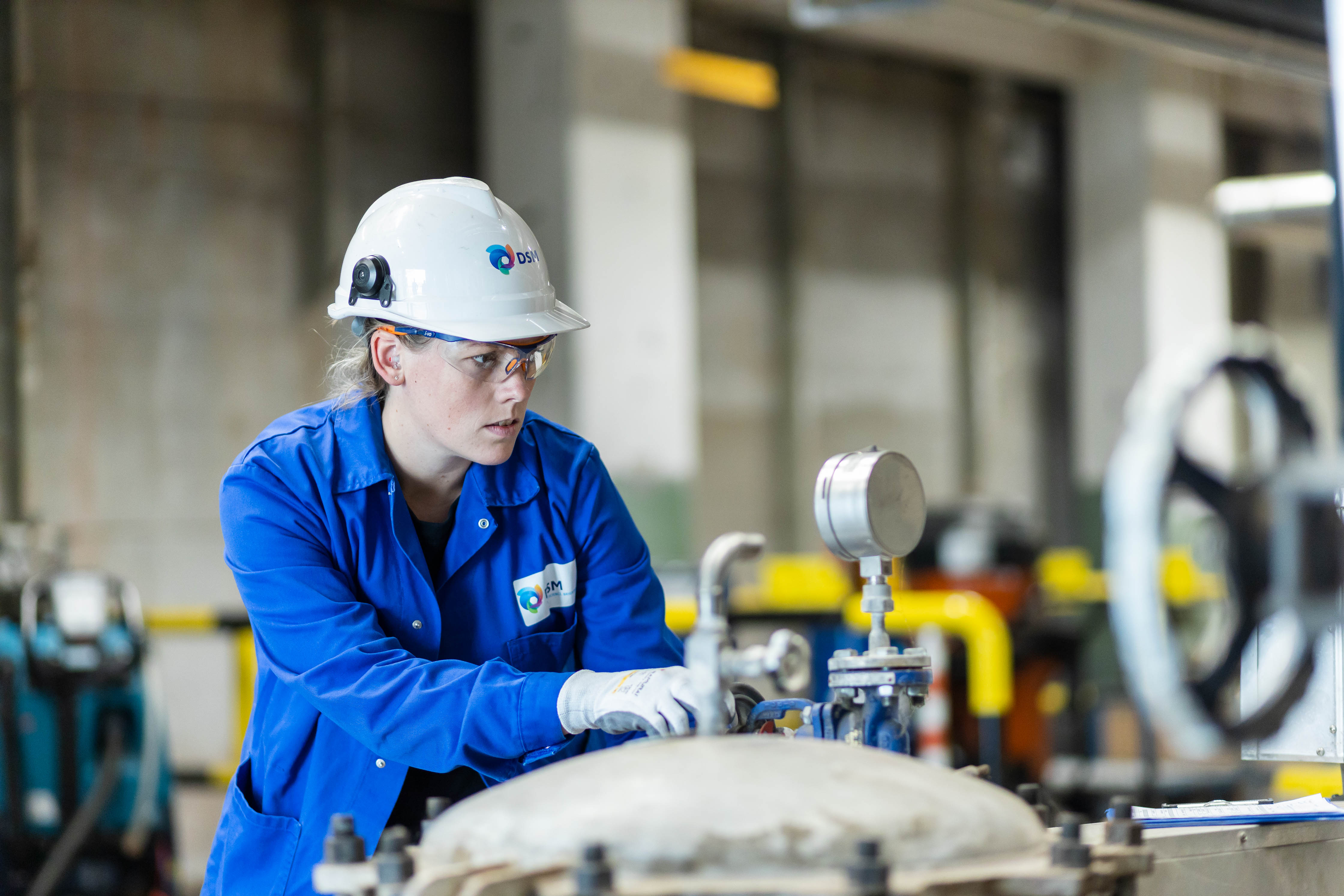 Procesoperator in opleiding voert controles uit op technische apparatuur in een industri&#xEB;le omgeving