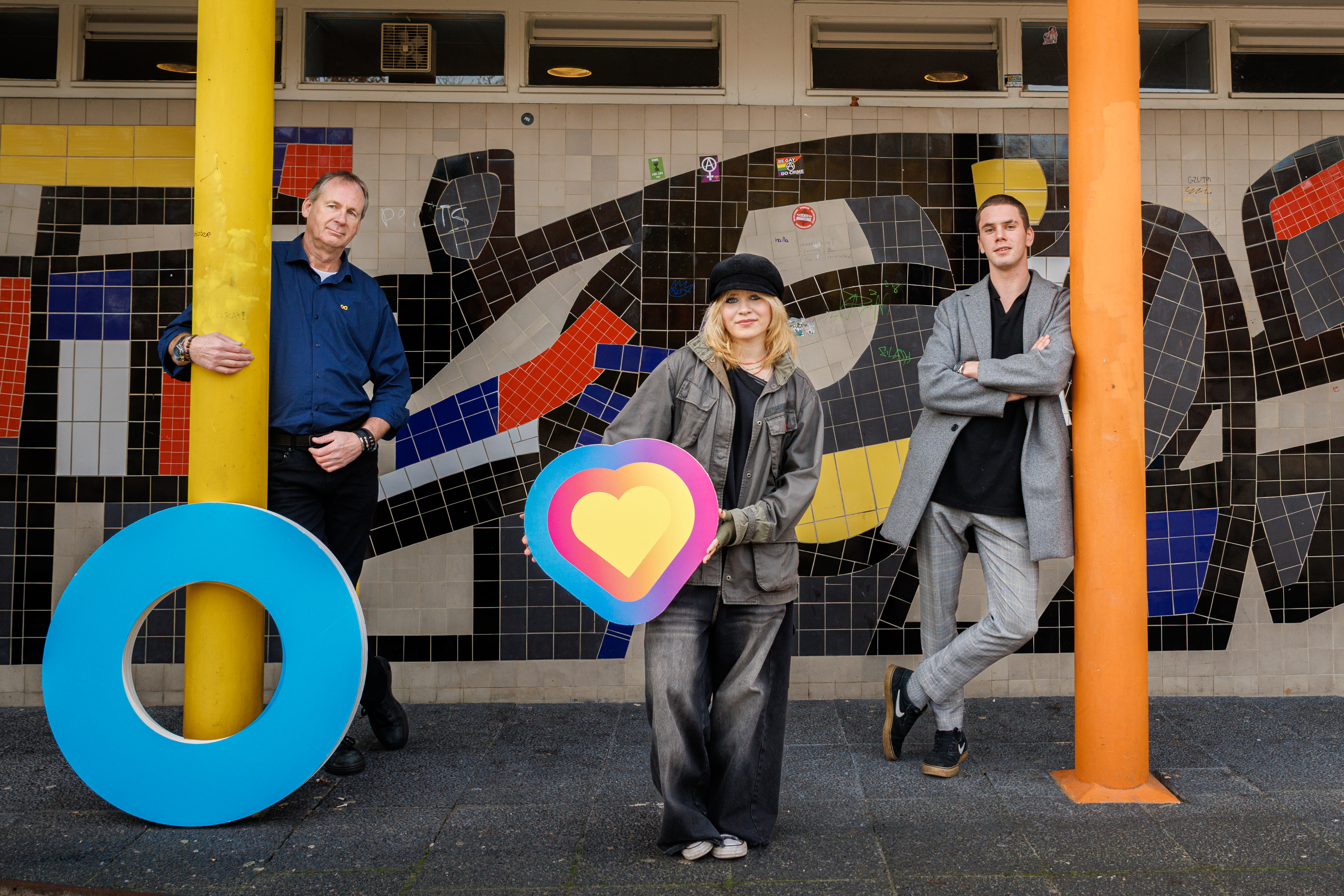 Drie personen bij kleurrijke muurschildering, passend bij introductiekamp Groen Goud voor nieuwe studenten