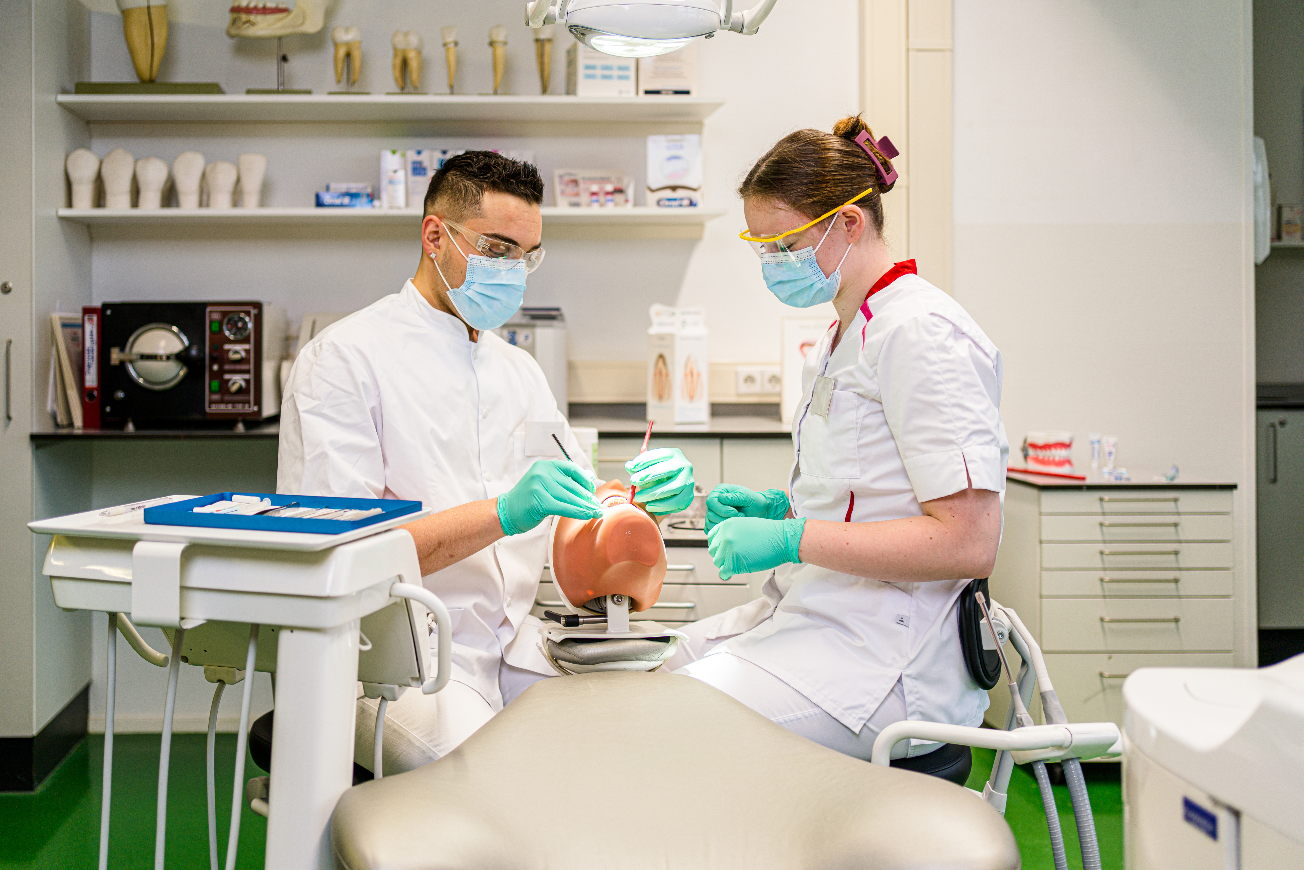 Tandartsassistenten in opleiding oefenen op een gebitsmodel in een praktijkruimte van Noorderpoort