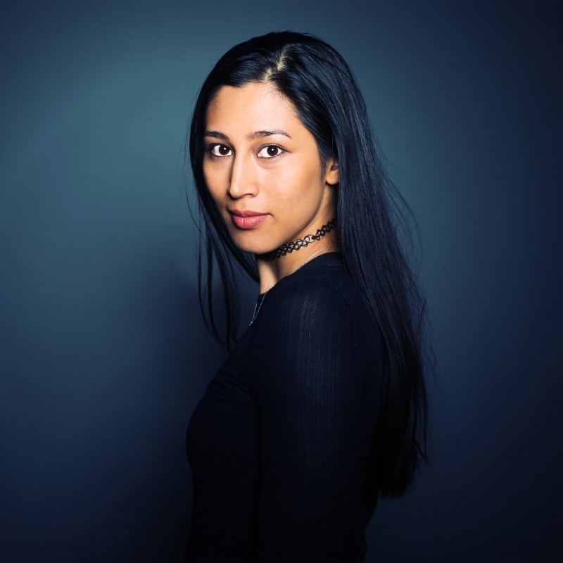 Deelnemer NEXT met een zelfverzekerde blik, gepresenteerd als inspirerend voorbeeld voor toekomstige studenten.