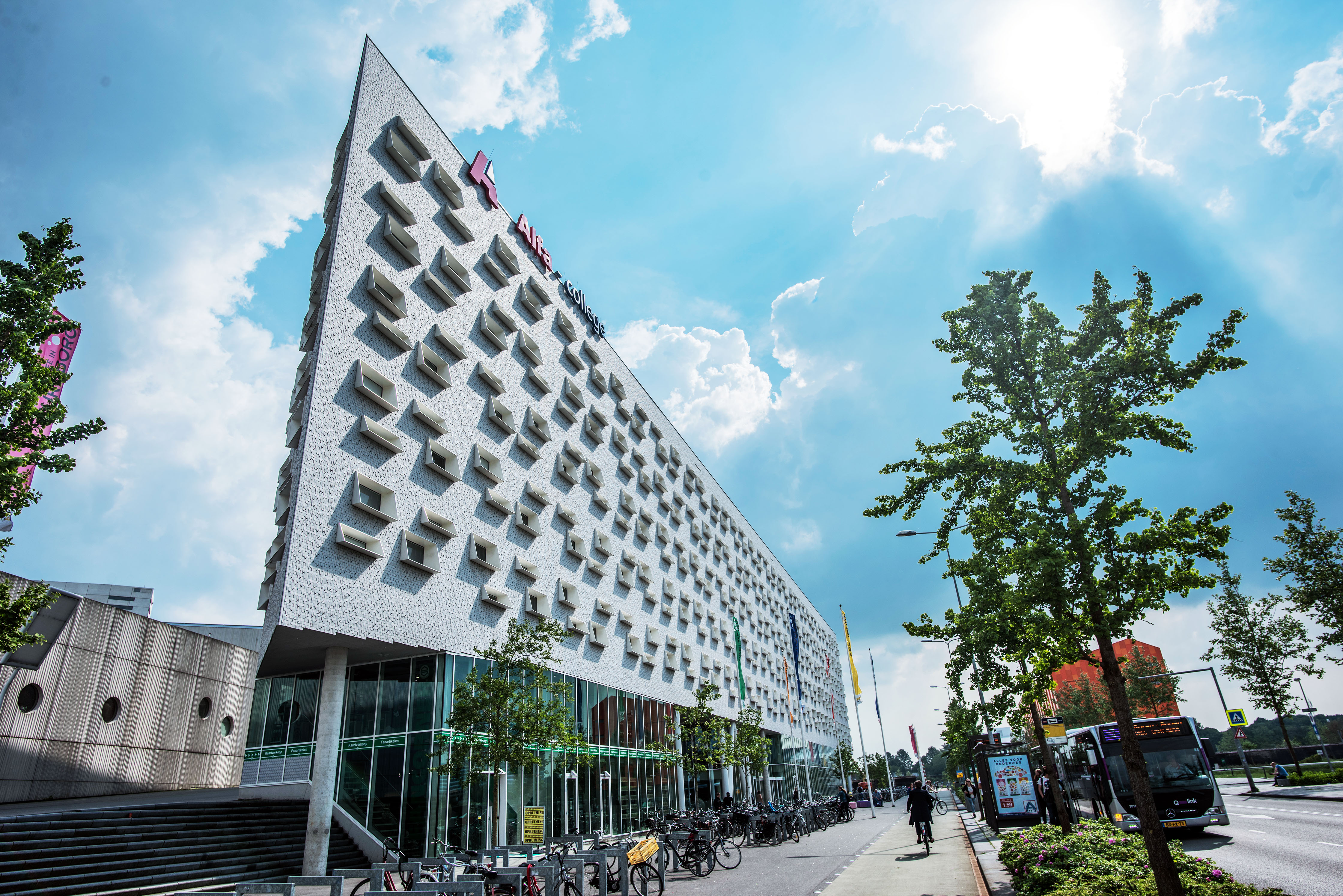 Moderne onderwijsinstelling aan de Boumaboulevard 573 in Groningen met studenten en fietsers buiten.