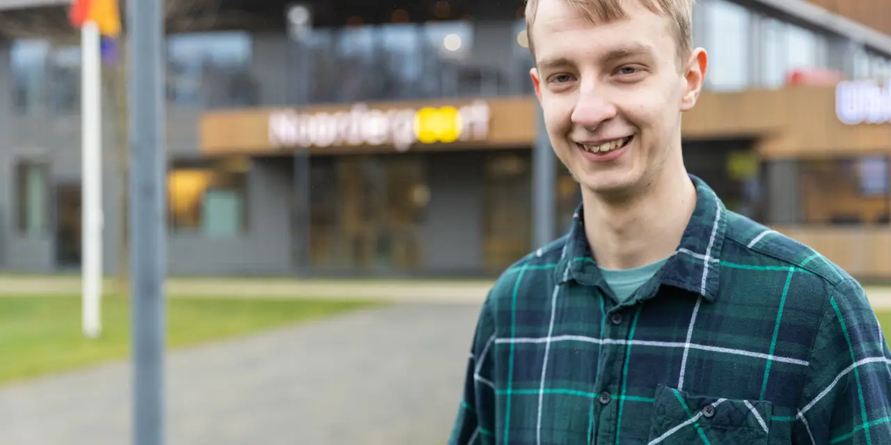 Dennis, lid van het inspiratieteam NEXT, staat voor de hoofdingang van Noorderpoort in Stadskanaal.